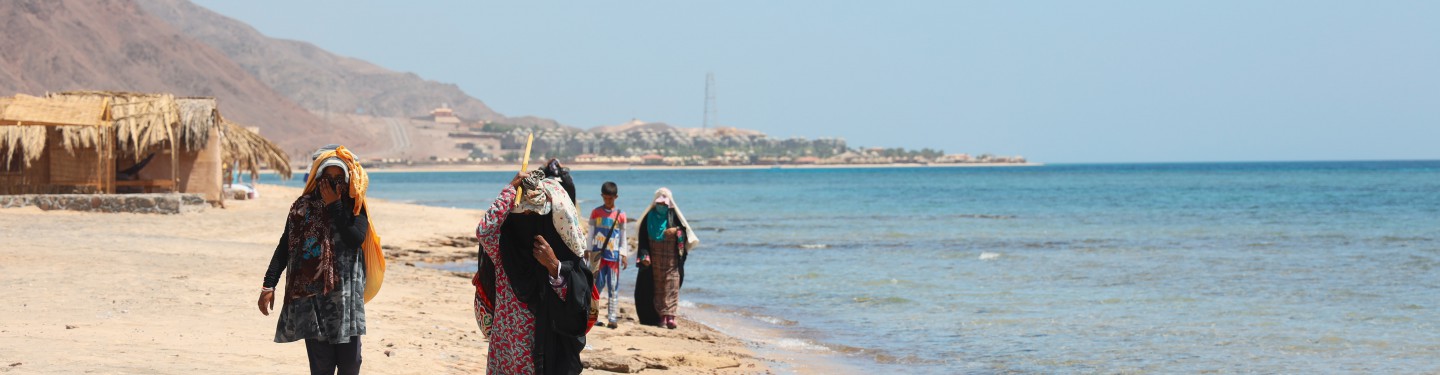 women walking along a beach in the middle east