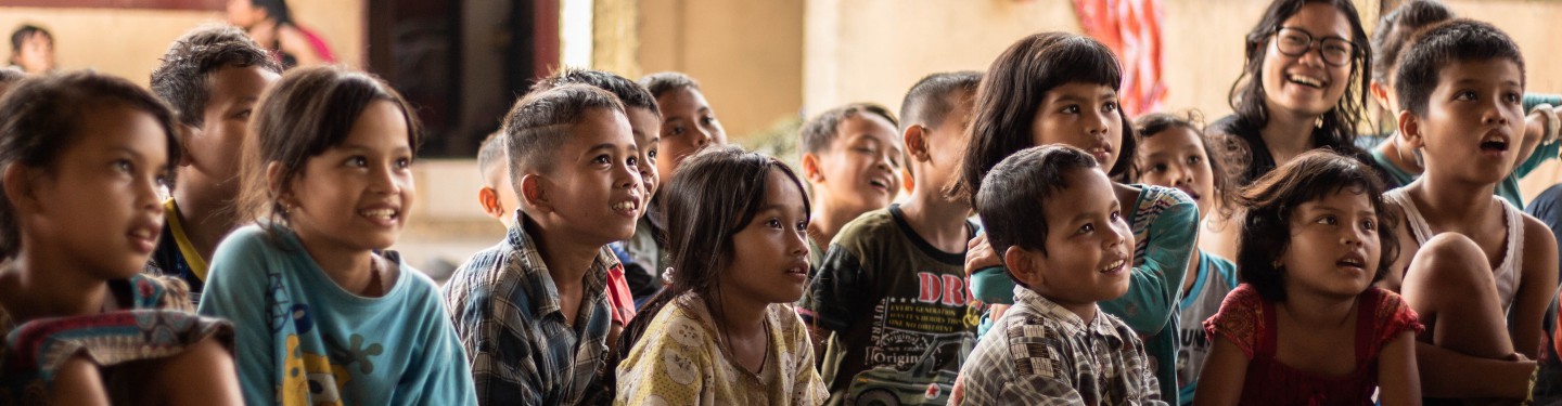 Children following a class while sitting on the floor