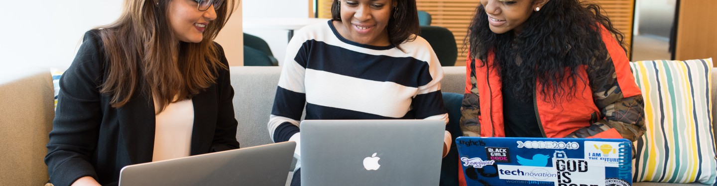 Three young women sitting in front of their laptops