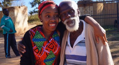 A young woman and an older man standing next to closely next to each other