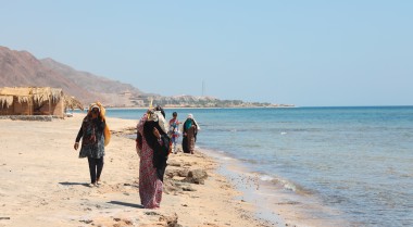 women walking along a beach in the middle east