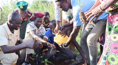 Community members in Uganda plant a tree